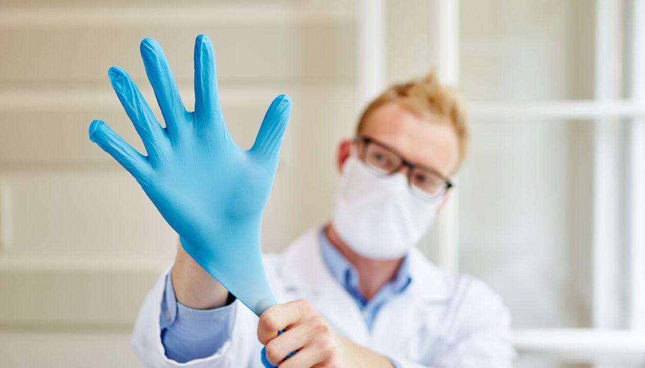 Der Arzt zieht zur Massage einen Handschuh an, um Prostatitis vorzubeugen